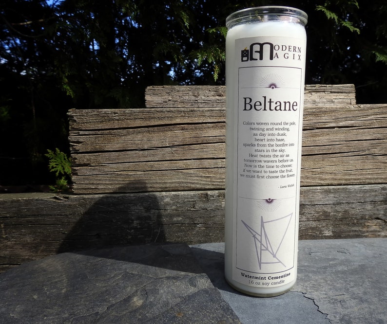 May include: White candle with a black and white graphic design and the text "Beltane" and "Watermint Cementine 10 oz soy candle".
