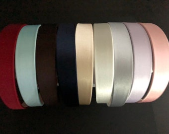 May include: A set of ten satin headbands in various colors, including red, blue, brown, light blue, cream, white, silver, lavender, and pink.