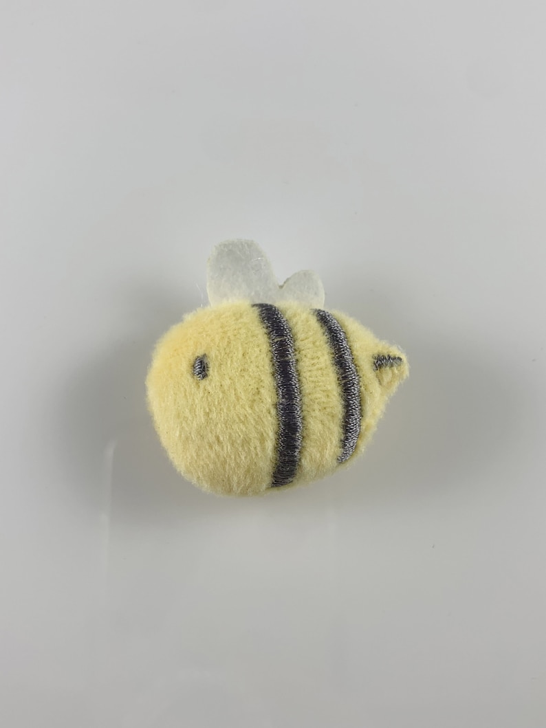 May include: A yellow plush bee with black stripes and white wings.