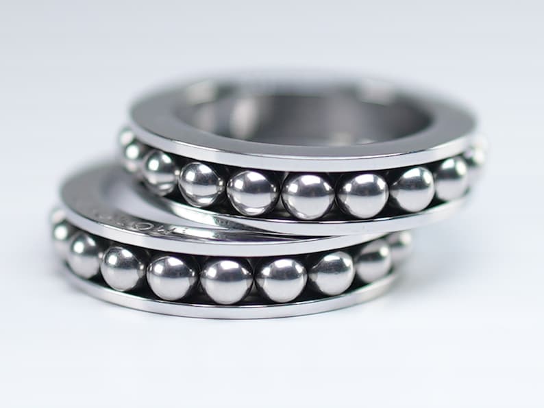 Puede incluir: Dos anillos de plata con una fila de peque&ntilde;as bolas de plata alrededor del borde.