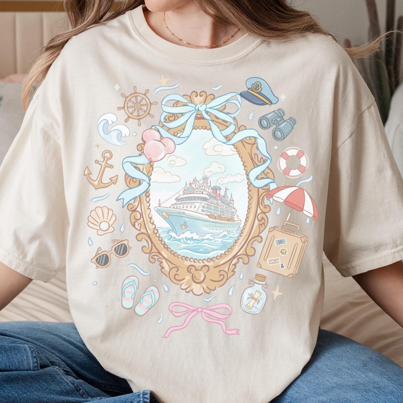 A woman wearing a white t-shirt with a graphic design featuring a cruise ship, various nautical and travel-related icons, and a decorative frame around the ship.