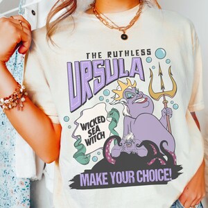 A person wearing a white t-shirt with a graphic design featuring the character Ursula from the Disney animated film "The Little Mermaid".