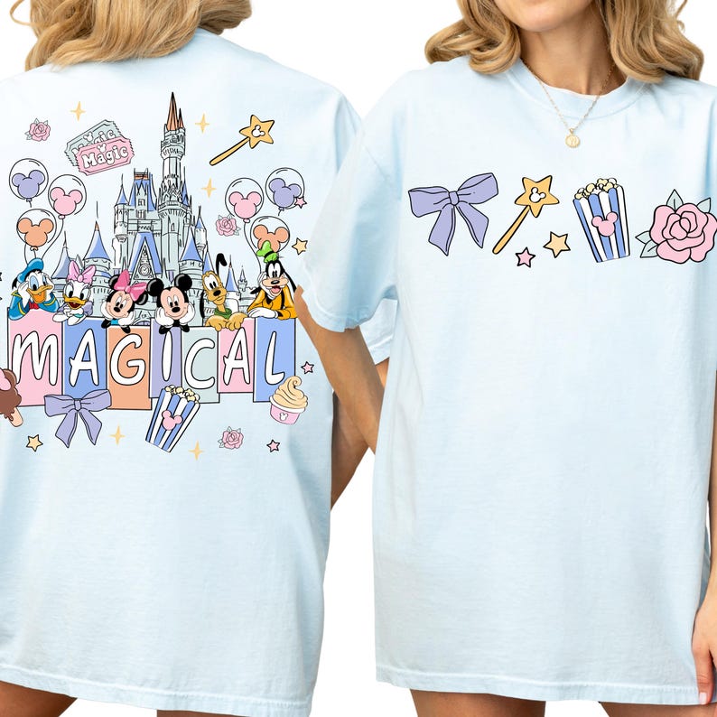 two women wearing white t-shirts with colorful Disney-themed graphics and text.
