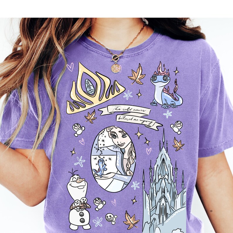 A person wearing a purple t-shirt with various cartoon-style illustrations and characters, including a princess, a castle, and other whimsical elements.