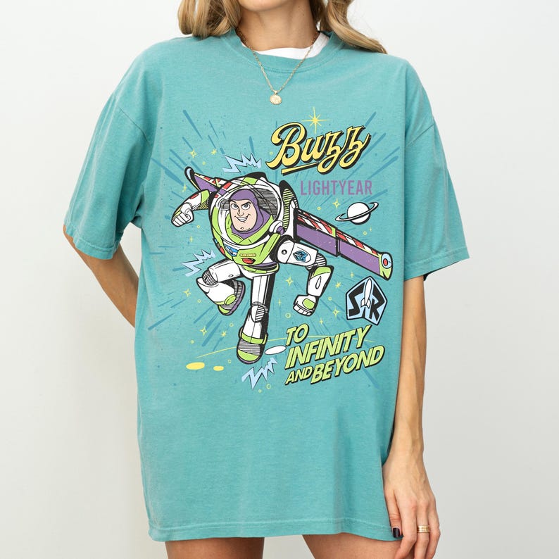 A person wearing a light blue t-shirt with a colorful graphic of Buzz Lightyear from the Toy Story franchise.