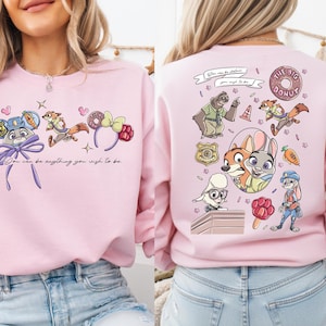 a woman wearing a pink sweatshirt with a cartoon character design on the back.