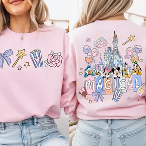 a woman wearing a pink sweatshirt with a Disney-themed design on the back.