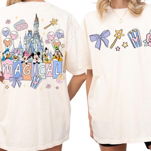 two white t-shirts with Disney characters and the word "MAGICAL" printed on them.