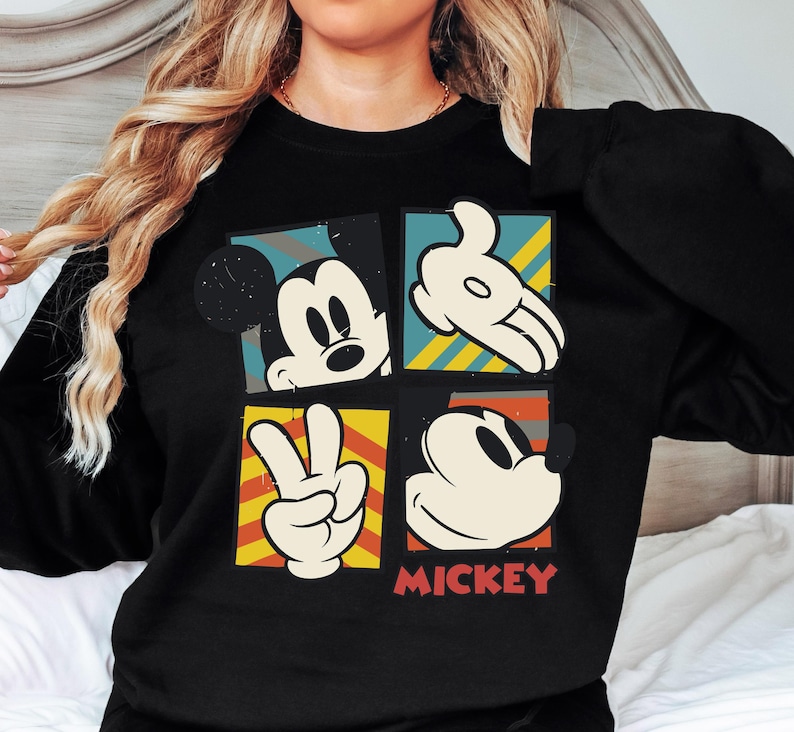 A woman wearing a black shirt with a graphic design featuring Mickey Mouse and the word "MICKEY" printed on it.