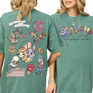 two green t-shirts with cartoon characters and various colorful illustrations.