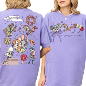 a purple t-shirt with a cartoon design of various cartoon characters, including a police officer, a fox, and other animals. The design also includes a message that says "You can be anything you wish to be".