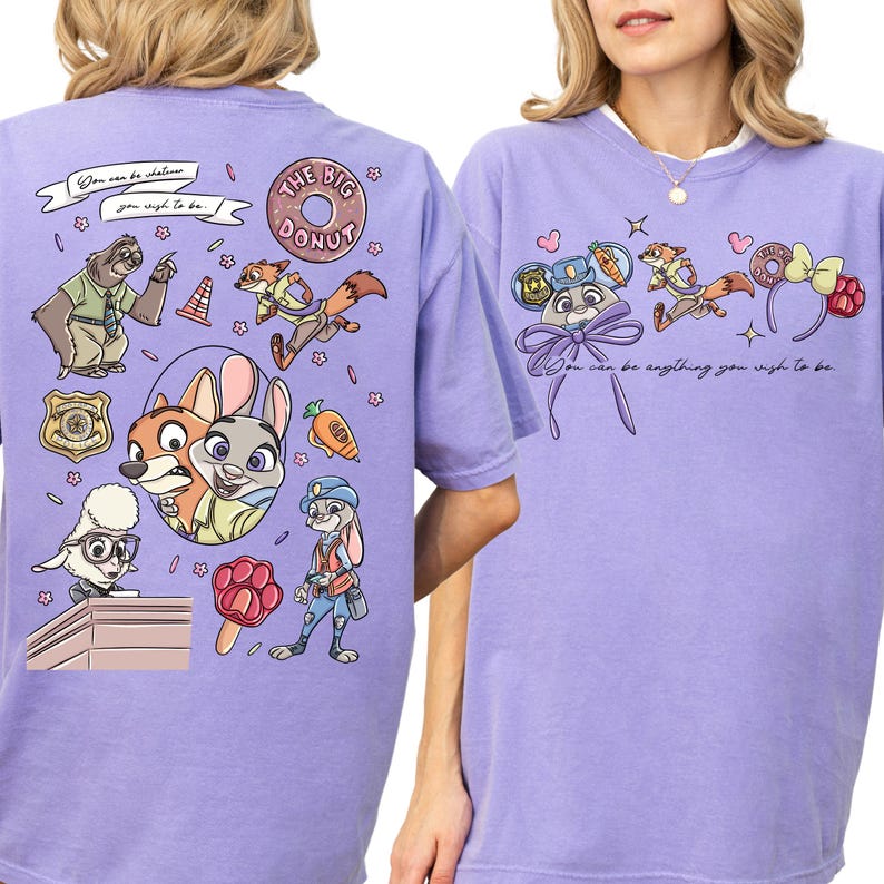 a purple t-shirt with a cartoon design of various cartoon characters, including a police officer, a fox, and other animals. The design also includes a message that says "You can be anything you wish to be".