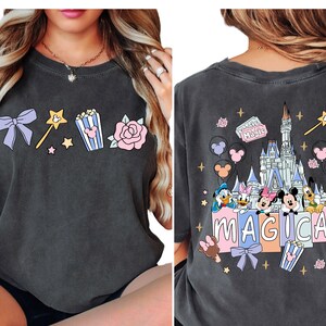 a woman wearing a black t-shirt with a Disney-themed design on the back.