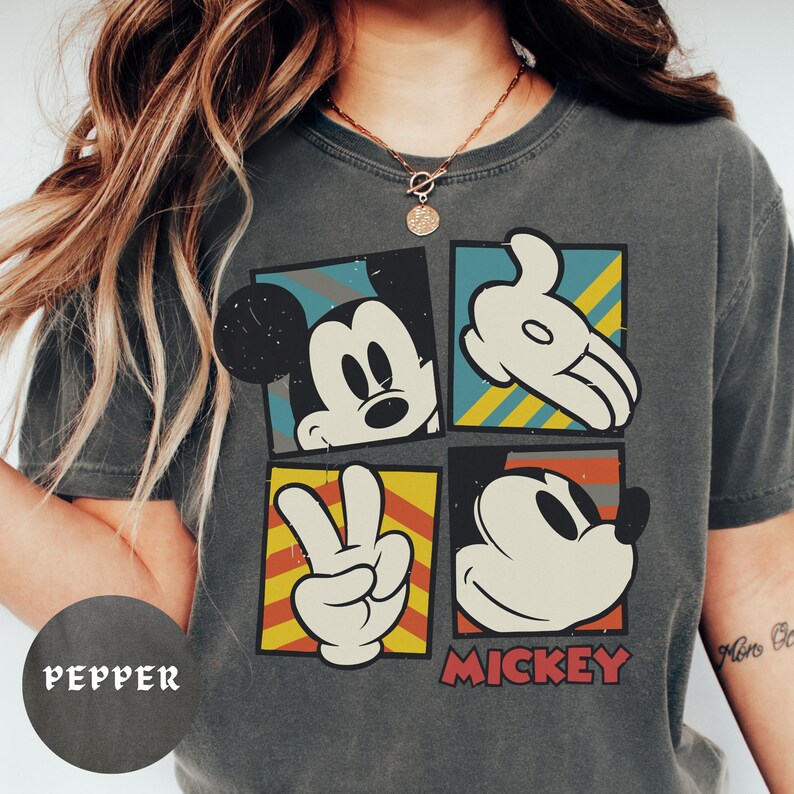 A person wearing a gray t-shirt with a graphic of Mickey Mouse and the word "PEPPER" printed on it.