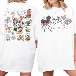 two white t-shirts with various Disney characters and Disney-themed graphics printed on them.