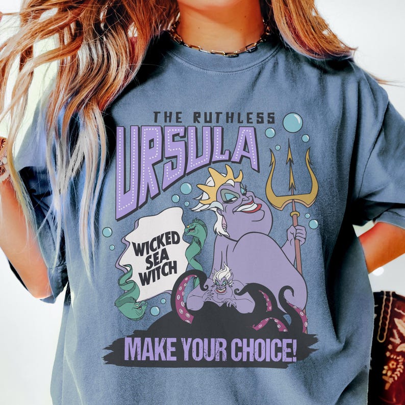 A person wearing a blue t-shirt with a graphic design featuring the character Ursula from the Disney film "The Little Mermaid".