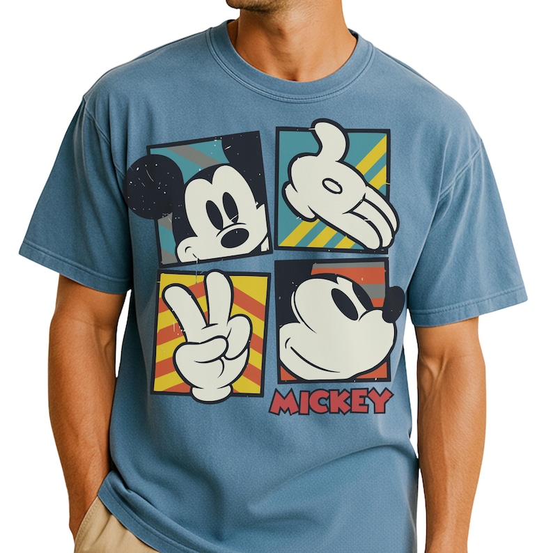 A man is wearing a blue t-shirt with a graphic design featuring the four iconic cartoon characters from the Disney movie Mickey Mouse.