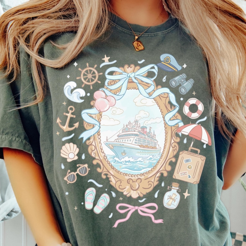 A person wearing a green t-shirt with a colorful graphic design depicting a cruise ship, various nautical elements, and a decorative frame.