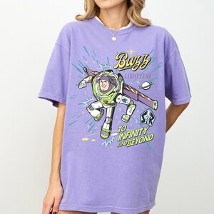 A person wearing a purple t-shirt with a graphic of Buzz Lightyear from the Toy Story franchise.