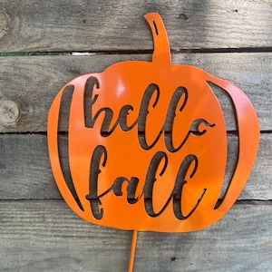 May include: Orange metal pumpkin cutout with the words "hello fall" in a decorative font.