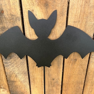 May include: Black metal bat silhouette with wings spread wide. The bat is attached to a metal stake, perfect for outdoor Halloween decor.