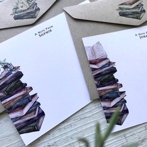 Puede incluir: Dos tarjetas blancas con una ilustraci&oacute;n de una pila de libros. La tarjeta superior dice "A Note From Sophie" y la tarjeta inferior dice "A Note From Jonah".