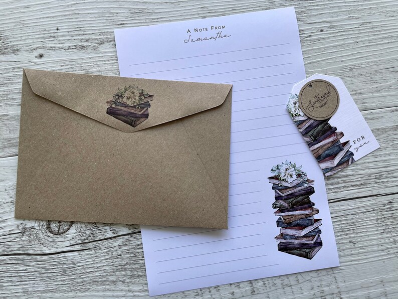 May include: A brown envelope with a sticker of a stack of books with white flowers on top. A white sheet of paper with lines and a sticker of a stack of books with white flowers on top. A white tag with the text "Sentimental  Edition" in a circle and the text "For you" below the circle.
