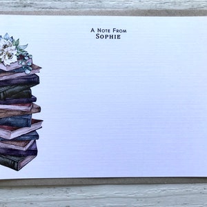Puede incluir: Una tarjeta blanca con una pila de libros y un arreglo floral en el lado izquierdo. El texto "A Note From SOPHIE" est&aacute; impreso en la parte superior de la tarjeta.