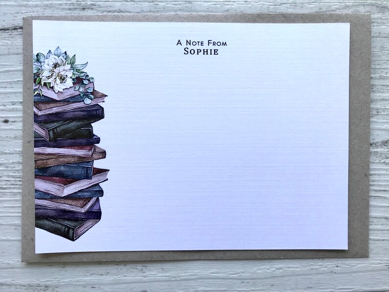 Puede incluir: Una tarjeta blanca con una pila de libros y un arreglo floral en el lado izquierdo. El texto "A Note From SOPHIE" est&aacute; impreso en la parte superior de la tarjeta.