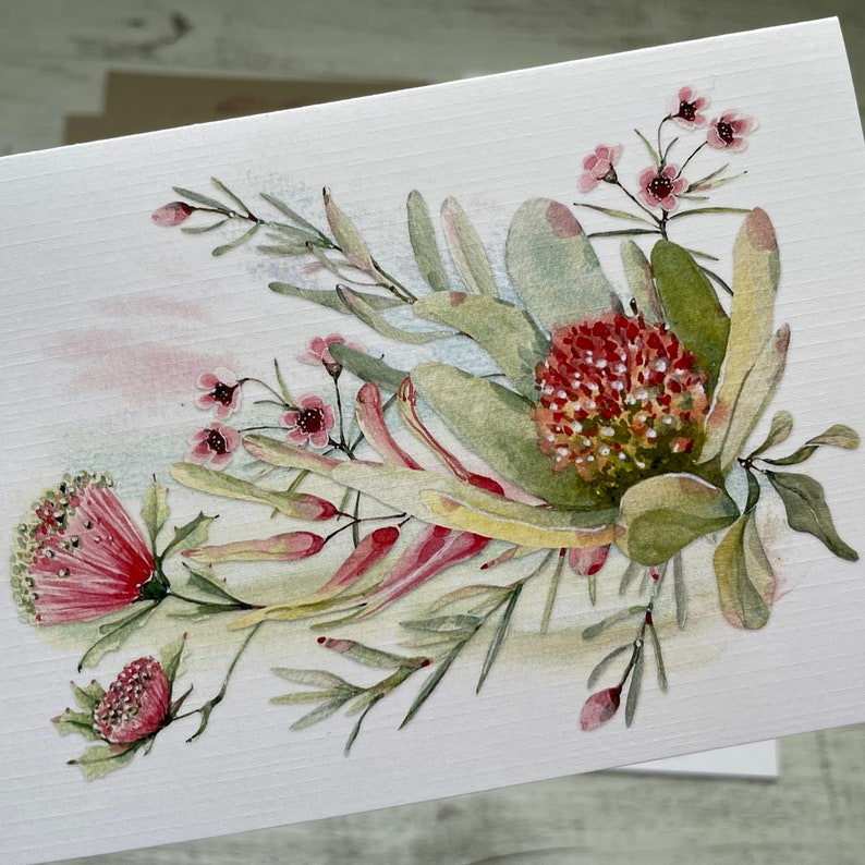 Op de afbeelding: Waterverf schilderij van een boeket roze en rode bloemen met groene bladeren op een witte achtergrond.