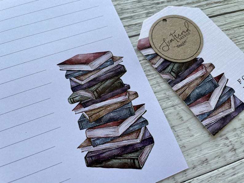 May include: A stack of vintage-style books with a brown, cream, and blue color scheme. The books are stacked on a white background with a tag that says "Scattered Seed Co."