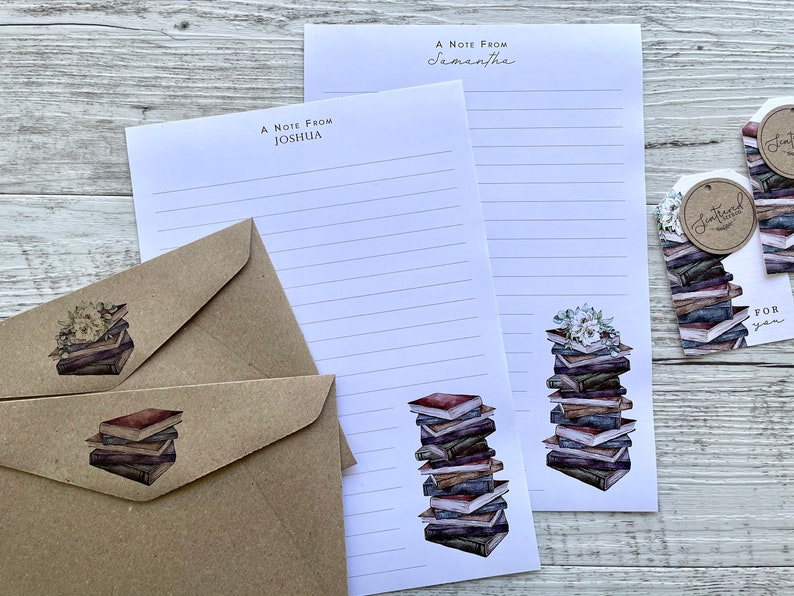 May include: Two white stationery note cards with lined paper and a stack of books illustration. The note cards have the text "A Note From Joshua" and "A Note From Samantha". Two brown envelopes with a stack of books illustration. Two brown gift tags with the text "The Bookish Kind" and "For You".