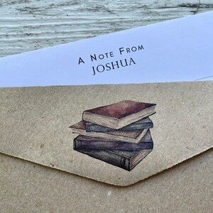 May include: A brown paper envelope with a white note that says "A Note From Joshua" and a watercolor illustration of a stack of books.