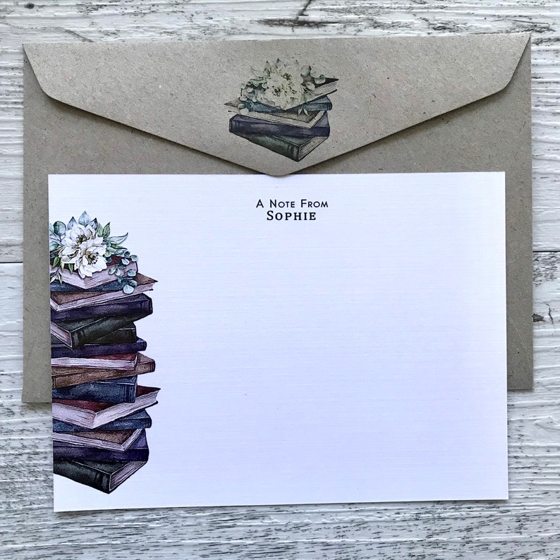 Puede incluir: Una tarjeta blanca con una pila de libros y flores en el lado izquierdo. El texto "A Note From Sophie" est&aacute; impreso en negro en la parte superior de la tarjeta.