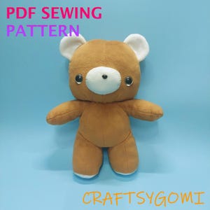 May include: A brown plush teddy bear with white inner ears and a white muzzle. The bear has two dark, round, glossy eyes and a small black nose. The text PDF SEWING PATTERN is at the top, and the text CRAFTSYGOMI is at the bottom of the image.
