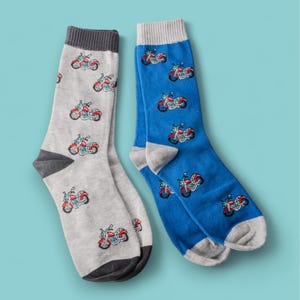 Könnte beinhalten: Ein Paar Socken mit einem Motorradmuster. Eine Socke ist grau mit schwarzem Besatz und die andere ist blau mit grauem Besatz.