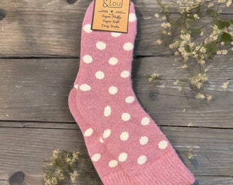 Puede incluir: Calcetines rosas acogedores con lunares blancos. Los calcetines están hechos de un material súper suave y súper esponjoso. La etiqueta dice "Jess & Lou" y "Super Fluffy Super Soft Cozy Socks".