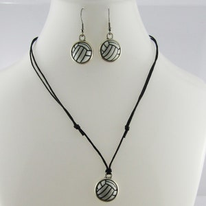 May include: A black cord necklace with a silver volleyball pendant. Matching silver volleyball earrings are included.
