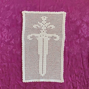 Könnte beinhalten: Weiße Häkeldeckchen mit Kreuzmuster.