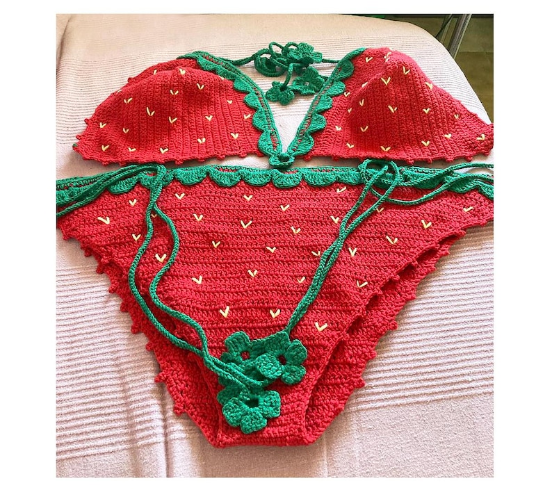 May include: Red and green crochet bikini top and bottom with a strawberry design. The bikini is handmade and has a scalloped edge.