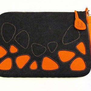 May include: A black felt laptop sleeve with a zip closure and a detachable orange felt strap. The sleeve has a unique design featuring orange felt cutouts in the shape of pebbles.
