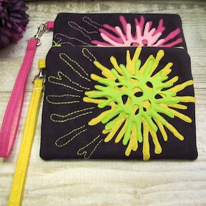 May include: Two fabric clutches with a dark brown background and colourful embroidered designs. The top clutch has a pink flower design, and the bottom clutch has a yellow and green flower design.