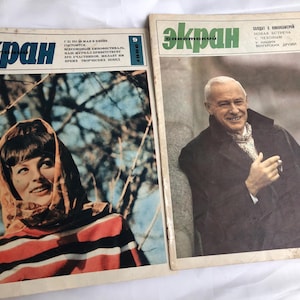 May include: Two vintage magazines with the word "Ekran" in Cyrillic script. One features a woman in a headscarf and striped shirt. The other shows a smiling man in a coat. Both magazines have text in Cyrillic.
