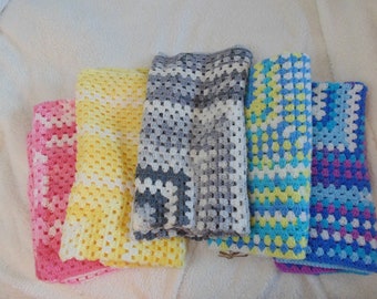 May include: Four crocheted baby blankets in pink, yellow, gray, and blue with white accents.