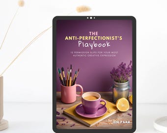 Puede incluir: Una tableta digital que muestra la portada de un libro con el título "THE ANTI-PERFECTIONIST'S Playbook" y el subtítulo "12 PERMISSION SLIPS FOR YOUR MOST AUTHENTIC CREATIVE EXPRESSION". La portada presenta un fondo morado con una taza de café, un tarro de lavanda y un vaso de pinceles.