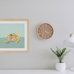 May include: A framed illustration of a bowl of fruit. The bowl is filled with bananas, apples, oranges, and grapes. The bowl is on a table with a green background.