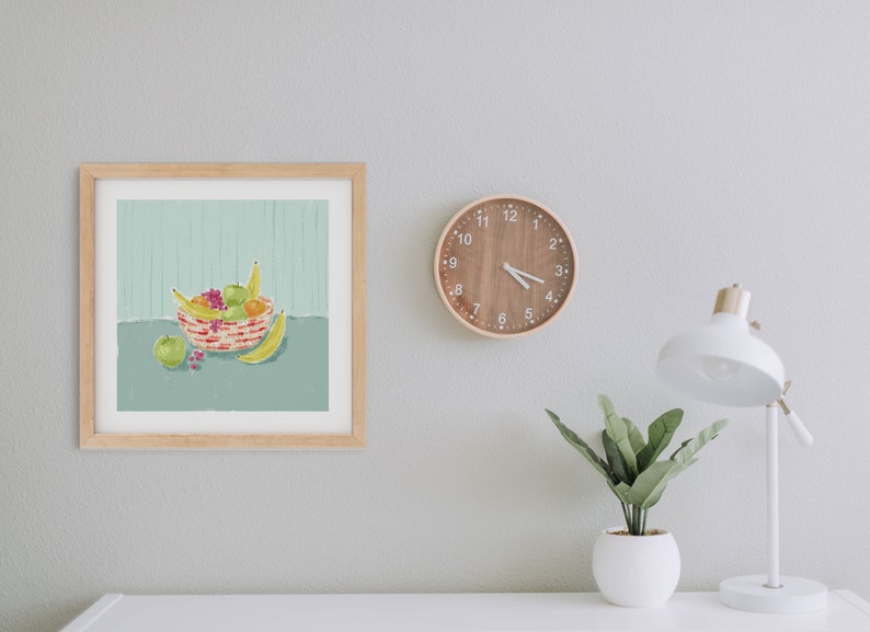 May include: A framed illustration of a bowl of fruit. The bowl is filled with bananas, apples, oranges, and grapes. The bowl is on a table with a green background.