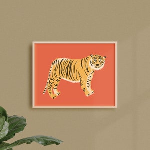May include: A framed illustration of a tiger standing on a coral pink background. The tiger is facing the left side of the image and has black stripes.