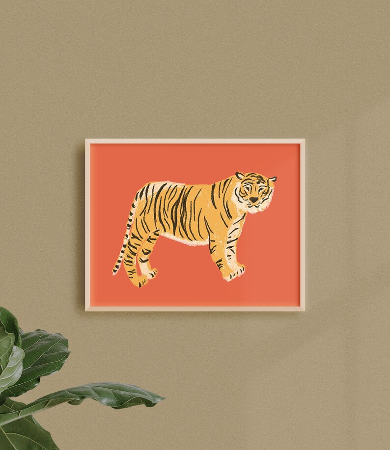 May include: A framed illustration of a tiger standing on a coral pink background. The tiger is facing the left side of the image and has black stripes.
