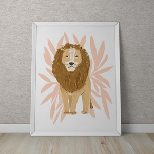 May include: A framed art print featuring a lion illustration. The lion is depicted in shades of brown and tan, with a prominent mane. Behind the lion are stylized, light pink leaf shapes. The artwork is framed in a white border.